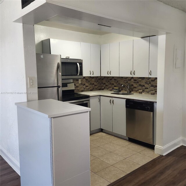 kitchen with light tile patterned floors, stainless steel appliances, and dark brown cabinets