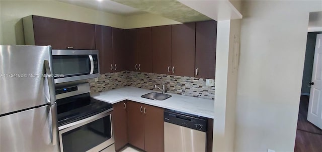 kitchen featuring appliances with stainless steel finishes, backsplash, dark brown cabinets, and sink