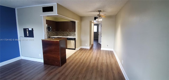 kitchen featuring light hardwood / wood-style flooring, a textured ceiling, tasteful backsplash, dark brown cabinetry, and stainless steel appliances