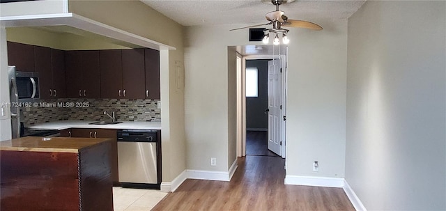 kitchen featuring decorative backsplash, ceiling fan, dark brown cabinetry, and stainless steel appliances