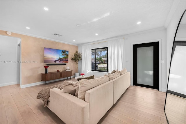 living room with light hardwood / wood-style floors and crown molding