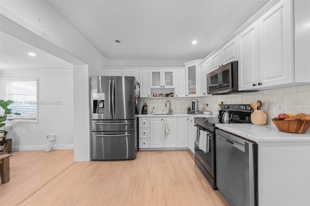 kitchen featuring white cabinets, backsplash, stainless steel appliances, and sink