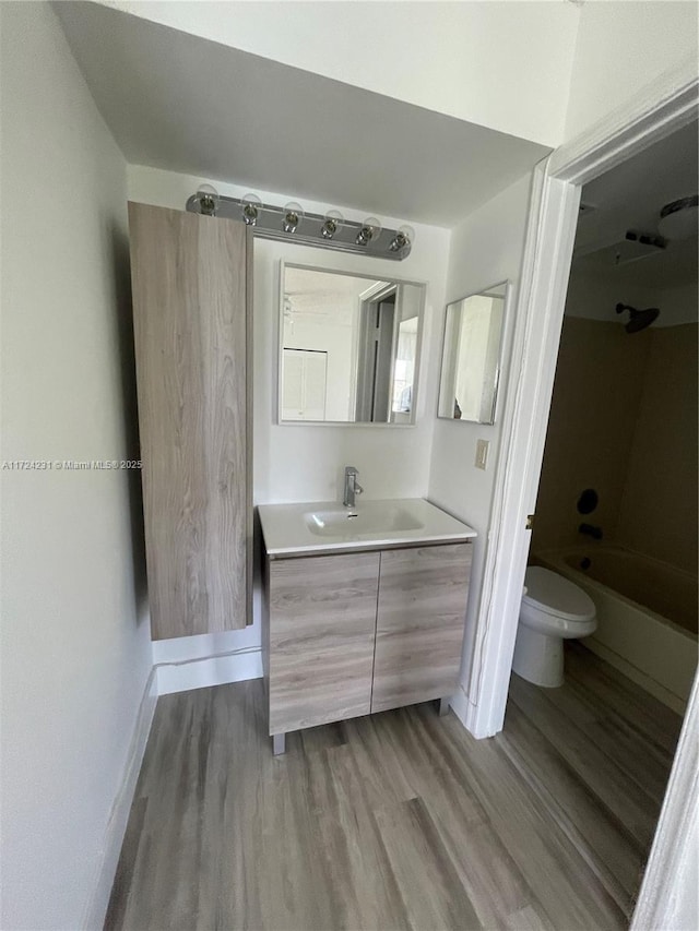 full bathroom featuring bathtub / shower combination, hardwood / wood-style floors, vanity, and toilet