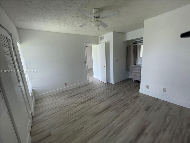 unfurnished bedroom with ceiling fan, wood-type flooring, and a textured ceiling