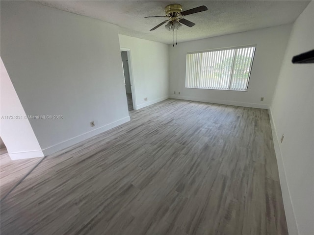 spare room featuring a textured ceiling, hardwood / wood-style flooring, and ceiling fan