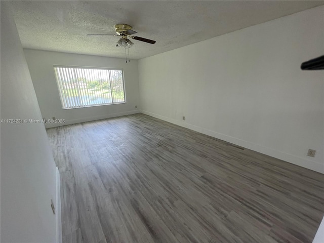 empty room with hardwood / wood-style floors, a textured ceiling, and ceiling fan