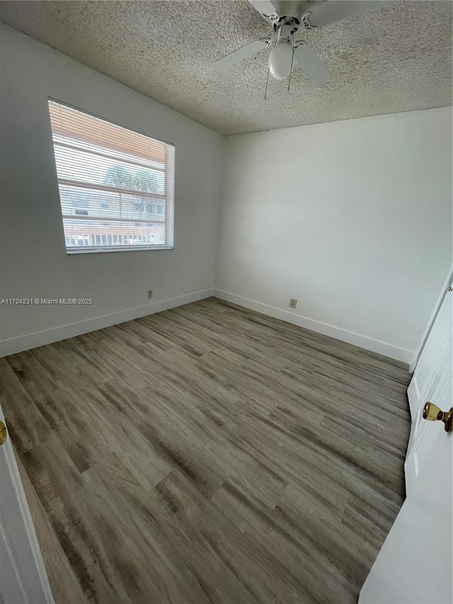 unfurnished room featuring wood-type flooring, a textured ceiling, and ceiling fan