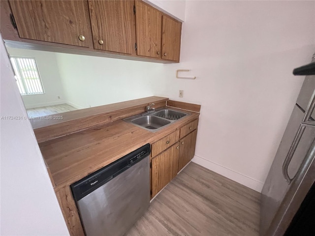 kitchen with dishwasher, light wood-type flooring, and sink