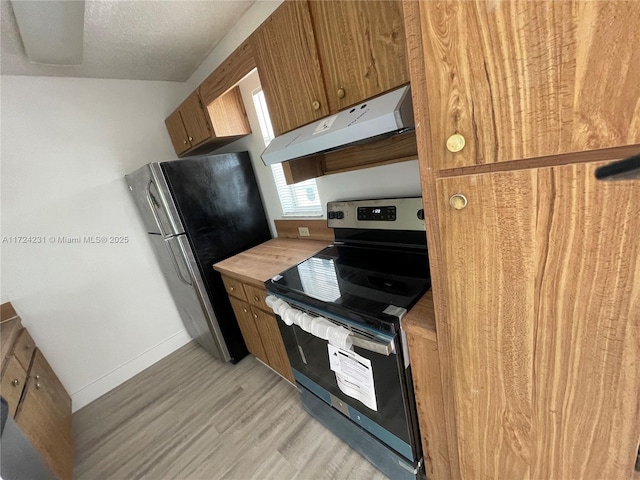 kitchen with light hardwood / wood-style flooring, a textured ceiling, and appliances with stainless steel finishes