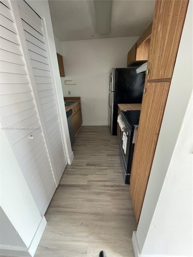 kitchen featuring range with electric cooktop, light hardwood / wood-style flooring, and stainless steel dishwasher