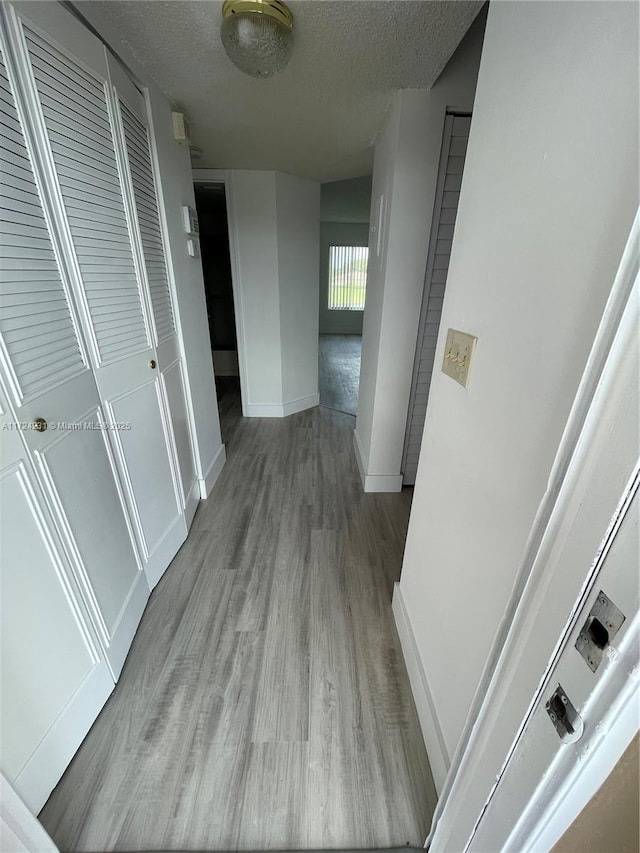 hallway featuring hardwood / wood-style flooring and a textured ceiling