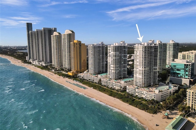 birds eye view of property featuring a water view and a beach view