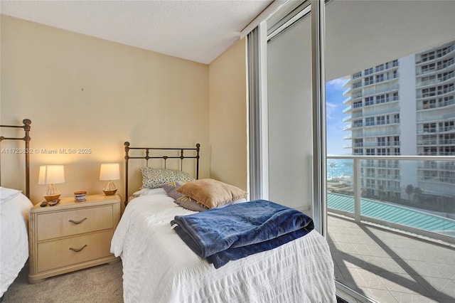 carpeted bedroom featuring a textured ceiling and access to outside