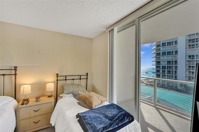 bedroom featuring a water view and a textured ceiling