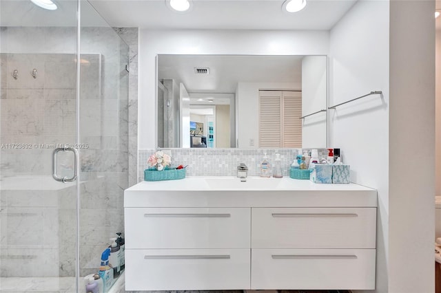 bathroom featuring walk in shower, backsplash, and vanity