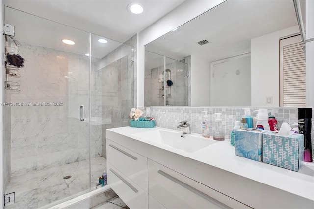 bathroom with tasteful backsplash, vanity, and a shower with door