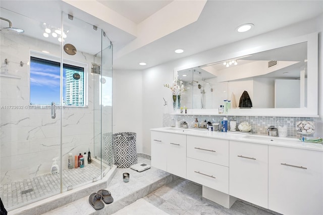 bathroom with vanity, backsplash, and walk in shower