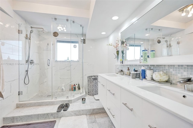 bathroom with tasteful backsplash, vanity, and a shower with door