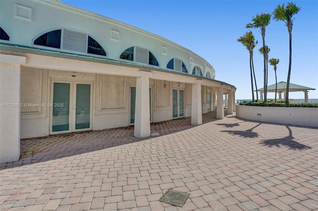 rear view of property featuring a patio area, a gazebo, and french doors