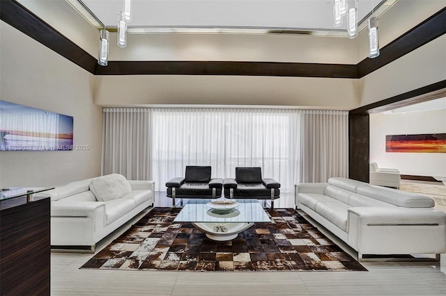 living room featuring plenty of natural light, tile patterned floors, and a towering ceiling