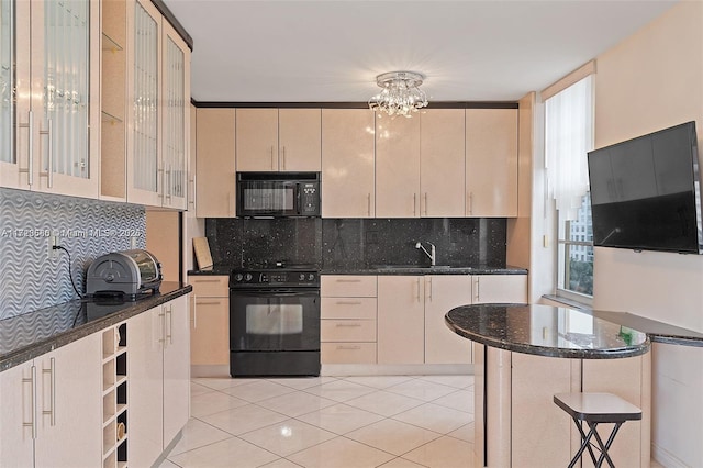 kitchen with dark stone countertops, black appliances, decorative backsplash, and sink