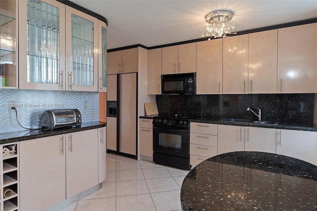 kitchen with black appliances, dark stone counters, an inviting chandelier, and decorative backsplash