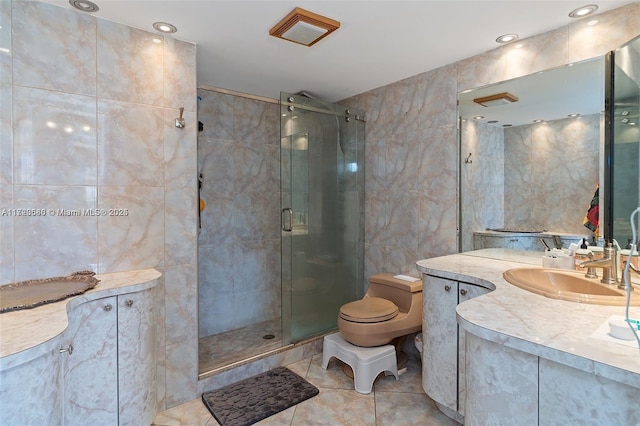 bathroom with toilet, tile patterned floors, vanity, tile walls, and an enclosed shower