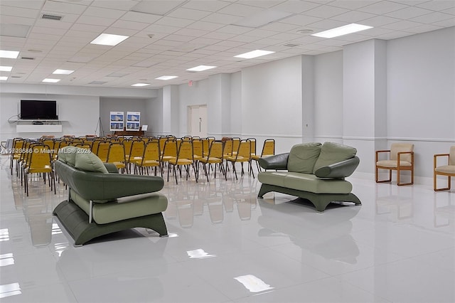 tiled living room with a paneled ceiling