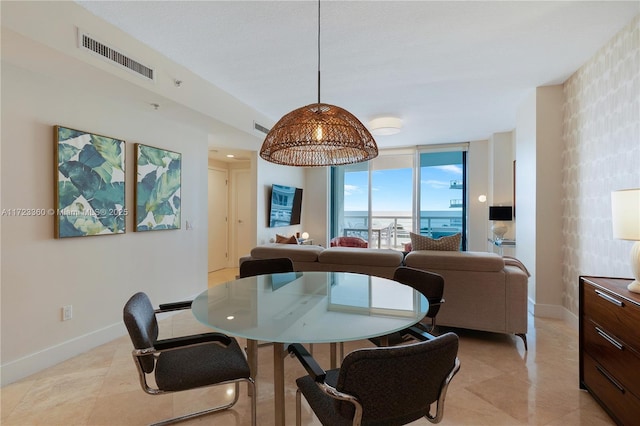 dining space with a water view and a wall of windows