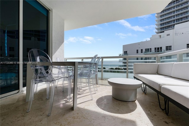 balcony with an outdoor living space and a water view