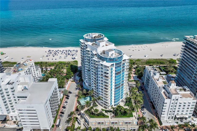 birds eye view of property with a water view and a beach view