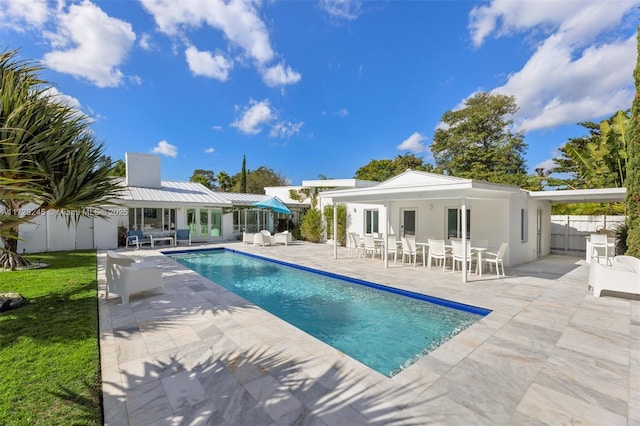 back of house with a patio area, a fenced in pool, and an outbuilding