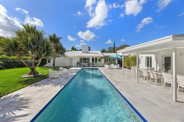 view of swimming pool featuring a lawn and a patio