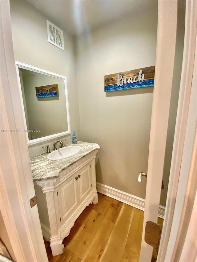 424 Lake Mirror Dr, Lake Placid, FL 33852 - bathroom with vanity, wood finished floors, and baseboards