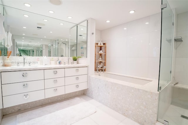 bathroom featuring shower with separate bathtub, vanity, and tile patterned floors