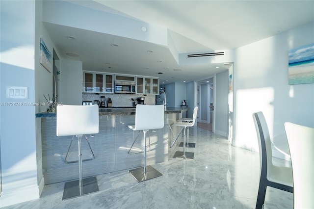 kitchen with a breakfast bar and decorative backsplash