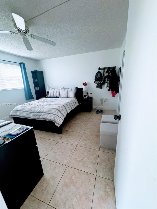 tiled bedroom with ceiling fan and a textured ceiling