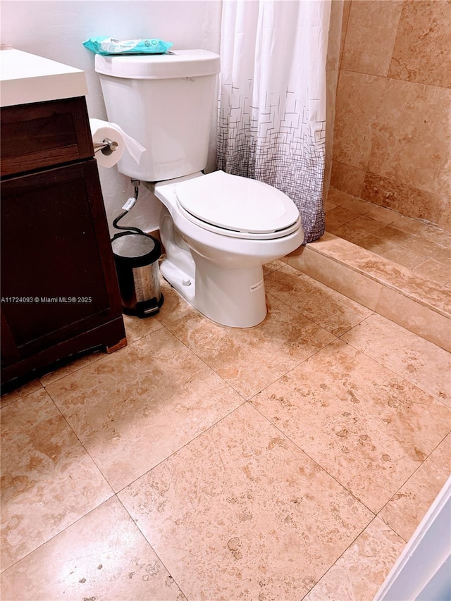 bathroom with vanity, curtained shower, and toilet