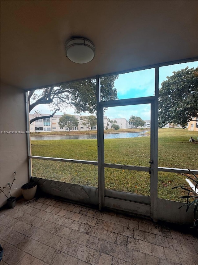 unfurnished sunroom featuring a water view