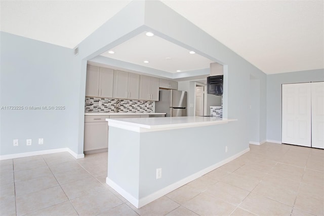 kitchen with decorative backsplash, sink, stainless steel refrigerator, and light tile patterned flooring