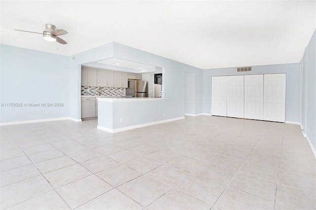 unfurnished living room featuring light tile patterned floors and ceiling fan