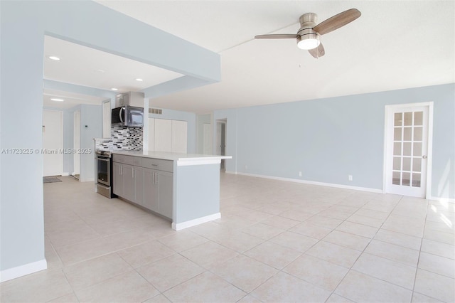 kitchen featuring decorative backsplash, ceiling fan, light tile patterned floors, and appliances with stainless steel finishes