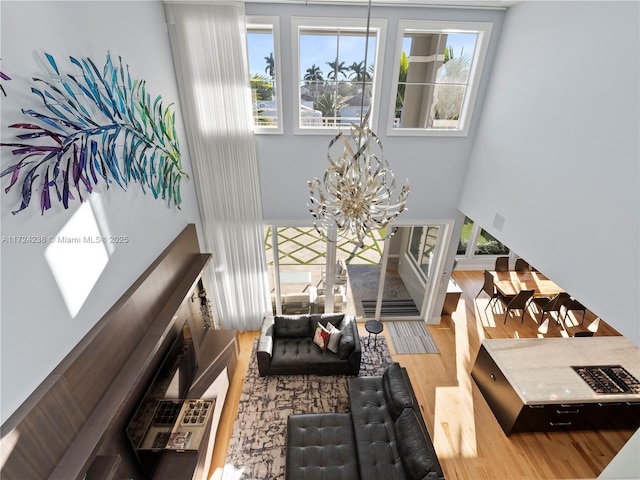 living room featuring a notable chandelier, a high ceiling, and hardwood / wood-style flooring