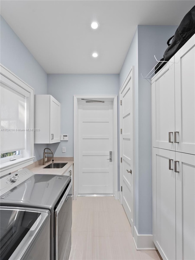 laundry area with washer and dryer, sink, and cabinets