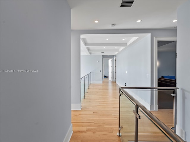 hall featuring beamed ceiling and light hardwood / wood-style flooring