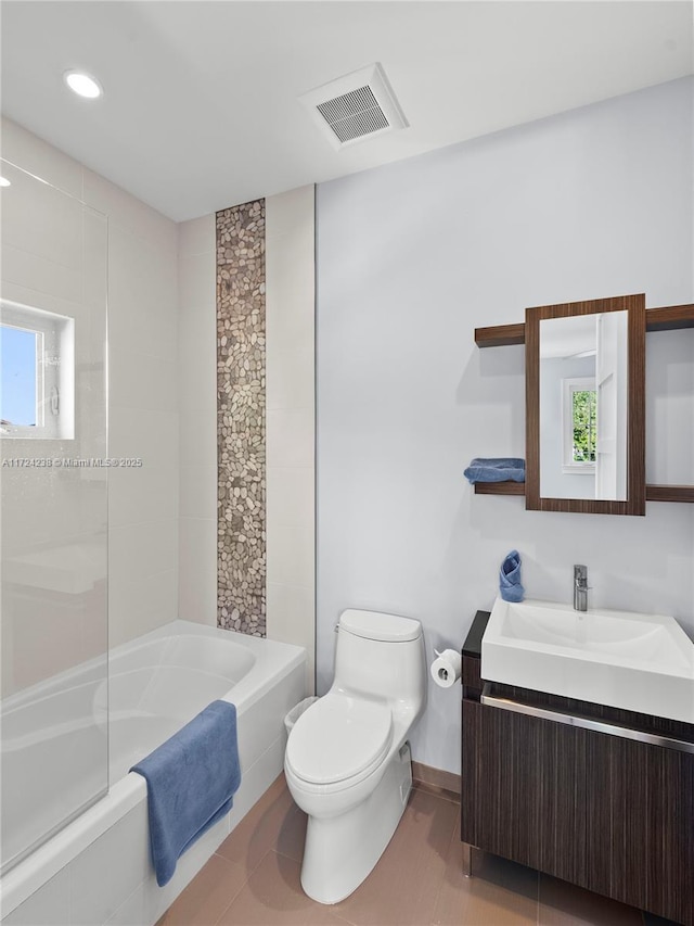 full bathroom featuring toilet, a healthy amount of sunlight, tile patterned flooring, and tiled shower / bath combo