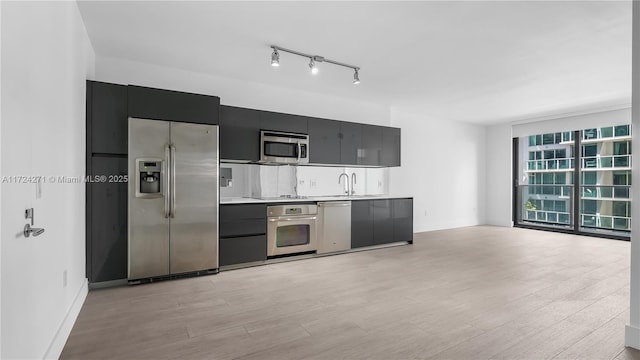 kitchen featuring light wood-type flooring, stainless steel appliances, and sink