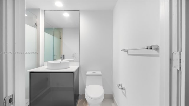 bathroom featuring vanity, toilet, and a shower with shower door