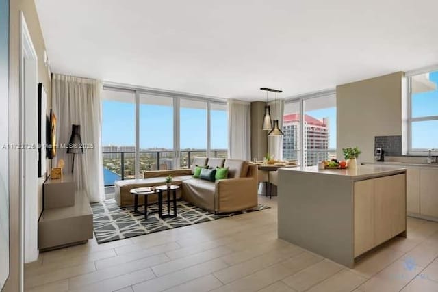 living room with light hardwood / wood-style flooring, expansive windows, a healthy amount of sunlight, and sink