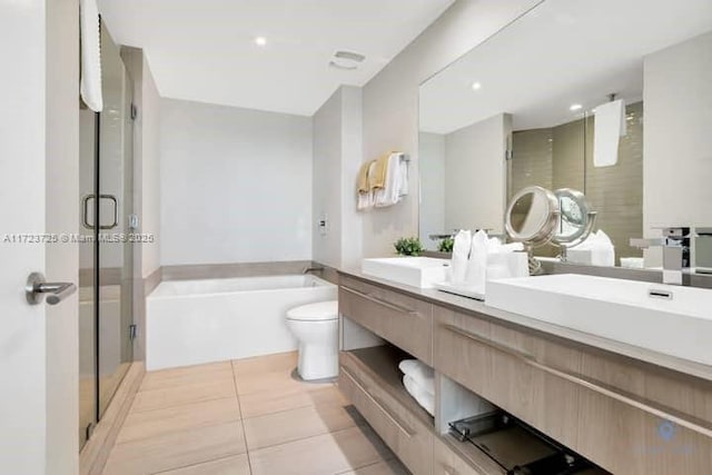 full bathroom featuring tile patterned flooring, vanity, shower with separate bathtub, and toilet